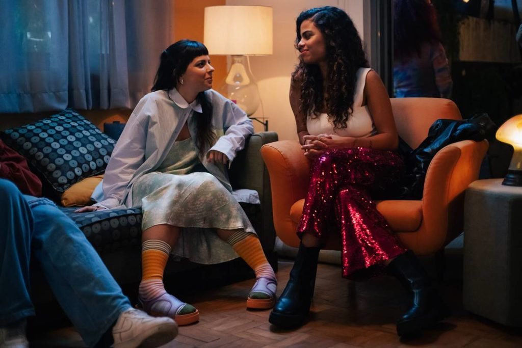 mulher sentada em sofa conversa com outra sentada em poltrona - metrópoles