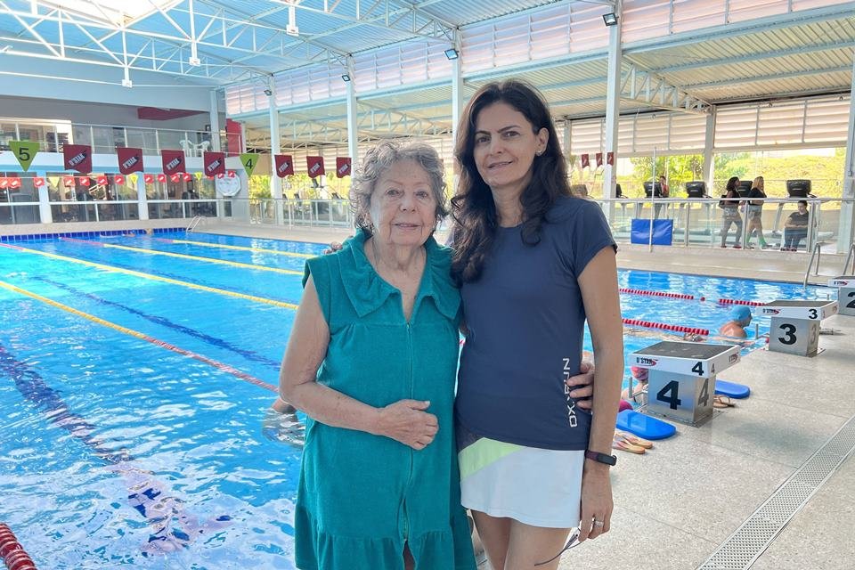 Color image: two women in front of the pool - Metrópoles