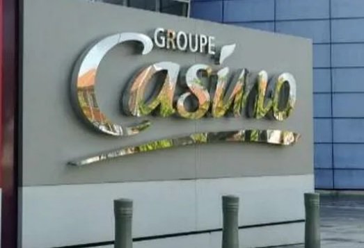 Imagem do logotipo do grupo francês Casino, em uma placa em frente a um prédio