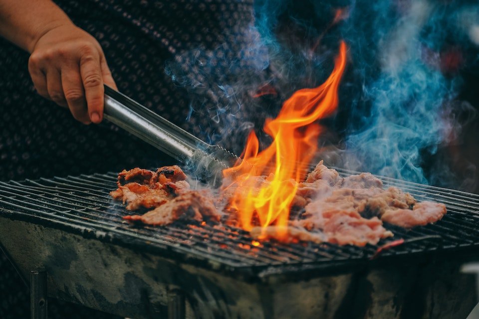 Na foto, uma pessoa fazendo churrasco em uma brasa - Metrópoles