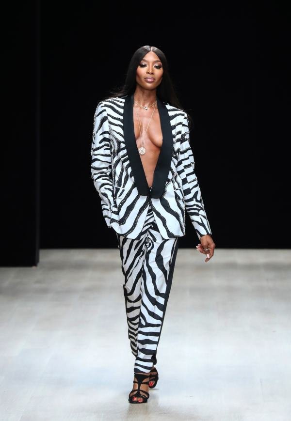 Na imagem com cor, mulher negra com cabelos pretos em um conjunto de terno de estampa de zebra - Metrópoles