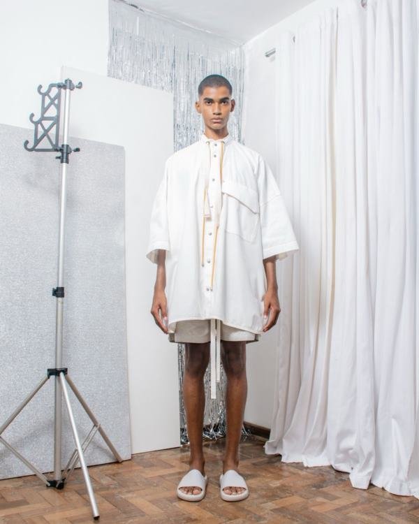 Na imagem com cor, um homem pardo com roupas brancas em pé - Metrópoles