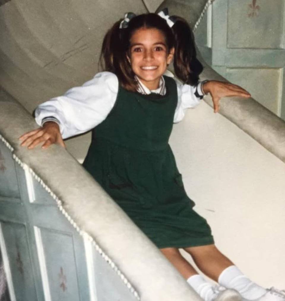 menina com camisa branca e vestido verde em escorregador - metrópoles