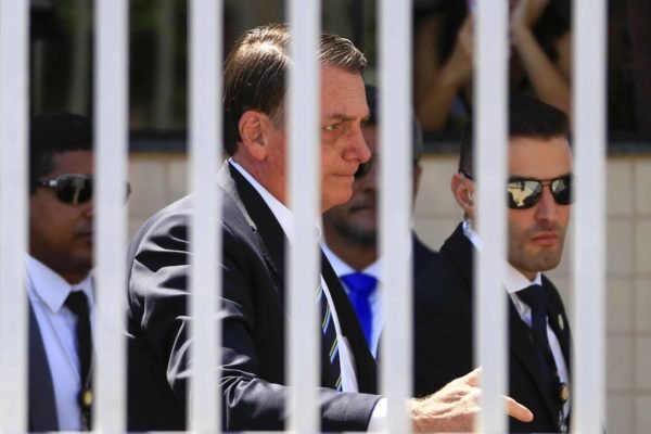 Presidente Jair Messias Bolsonaro passa por grades antes da coletiva de imprensa - metrópoles