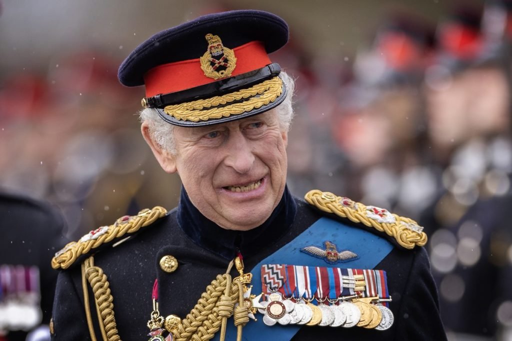 Foto colorida de homem branco, idoso e sorridente, com trajes militares britânicos - Metrópoles