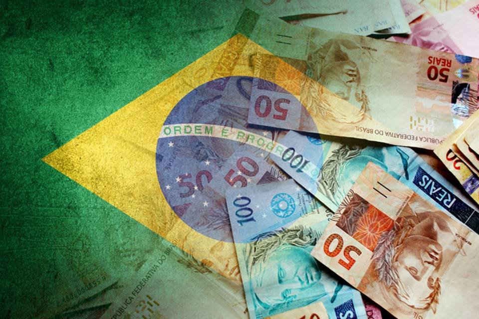 Ilustração mostra notas de real em cima de bandeira do Brasil - Metrópoles