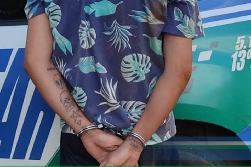 Imagem colorida mostra homem é preso em Goiânia por suspeita de feminicídio. Ele é visto de costas, com as mãos algemadas - Metrópoles