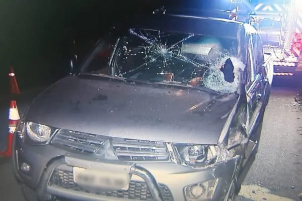 Imagem colorida mostra carro com vidro quebrado após acidente de trânsito em Curitiba que matou um jovem