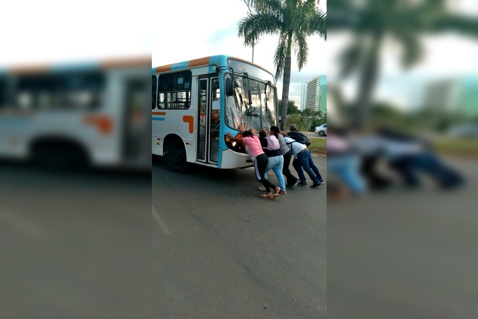 passageiros empurrando ônibus que quebrou