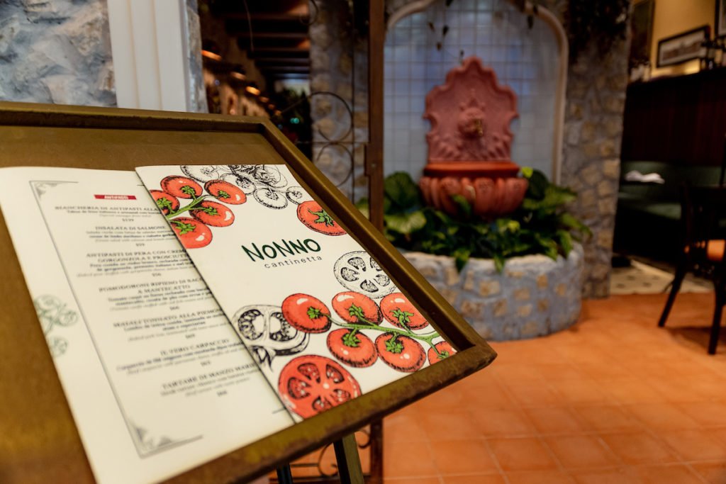 Na foto, um menu físico com uma fonte ao fundo - Metrópoles
