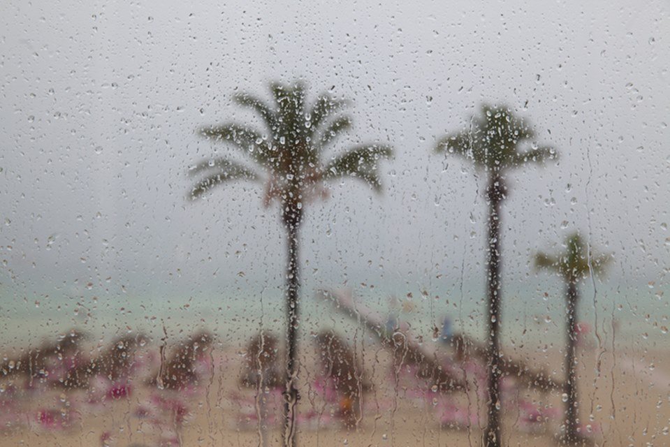 Imagem colorida: janela com chuva na praia - Metrópoles