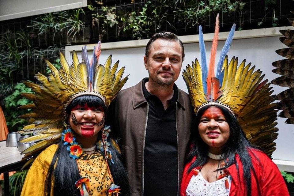 Foto colorida do encontro entre DiCaprio, Sonia Guajajara e Célia Xakriabá em Cannes - Metrópoles