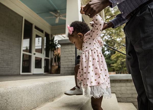 Pai ajuda bebê negra a subir degraus - Metrópoles