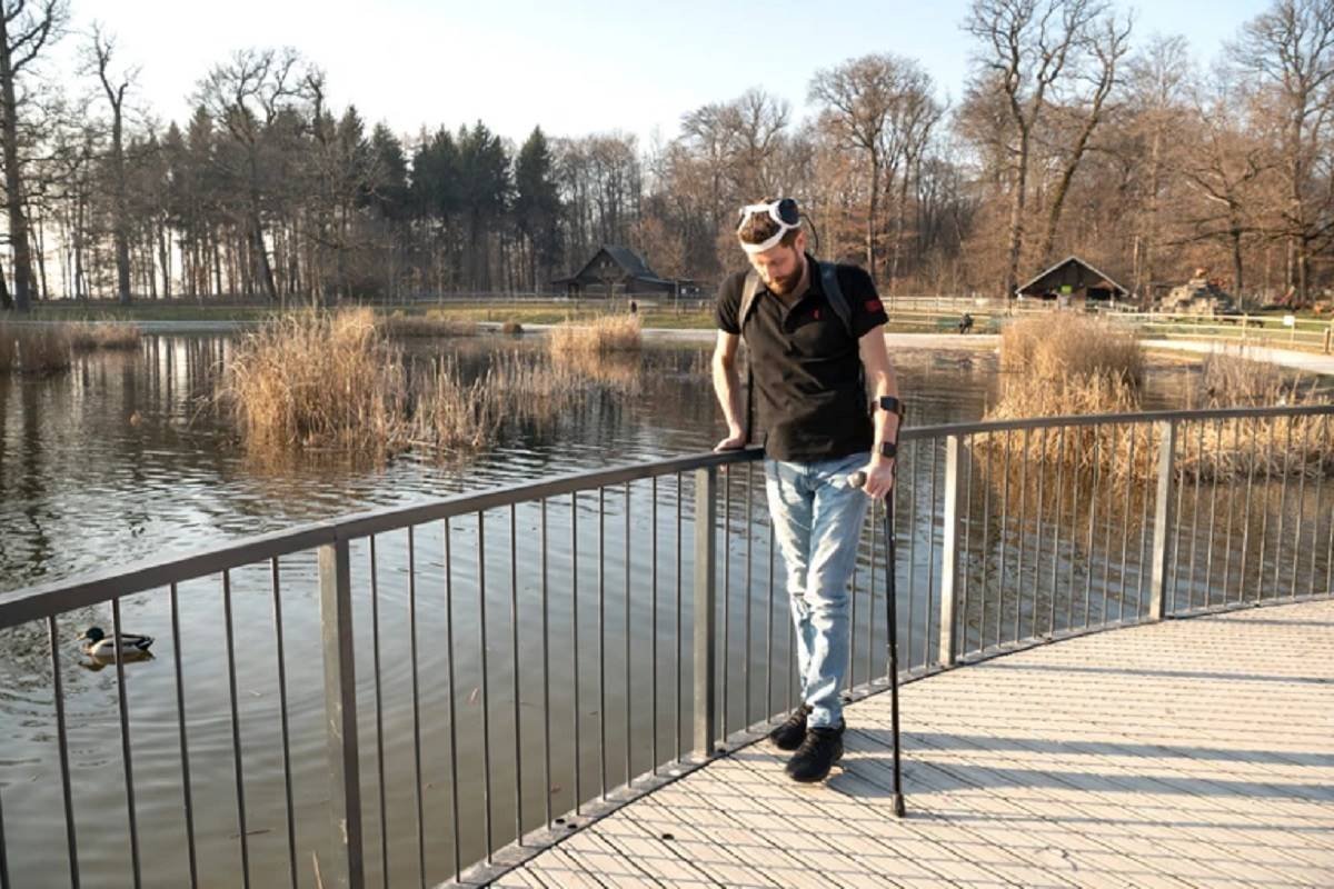 Homem tetraplégico caminhando com ajuda de aparelhos