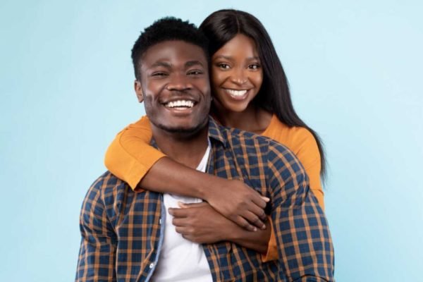 homem e mulher negra se abraçando e sorrindo - Metrópoles
