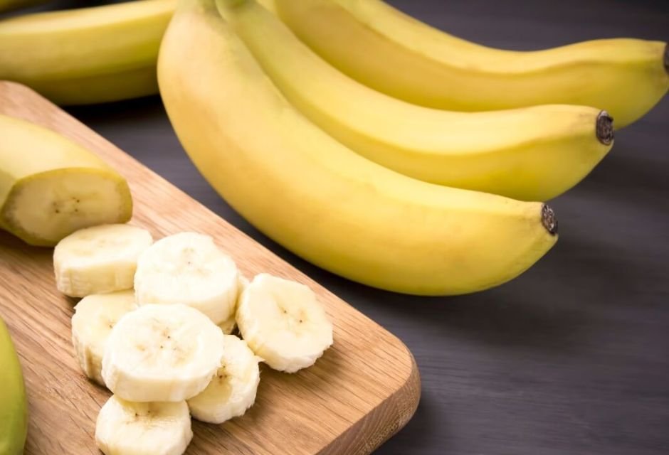 Banana cortada e interira em cima da mesa