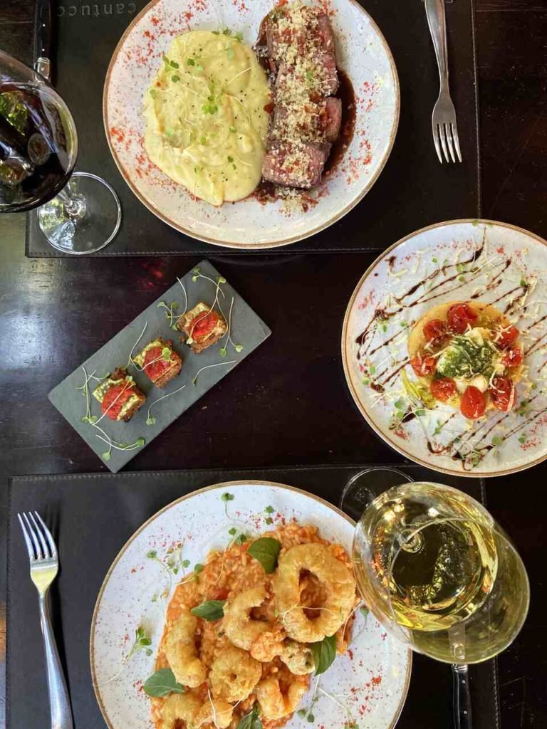 Na foto, a visão de cima de uma mesa com vários pratos e comidas diferentes - Metrópoles
