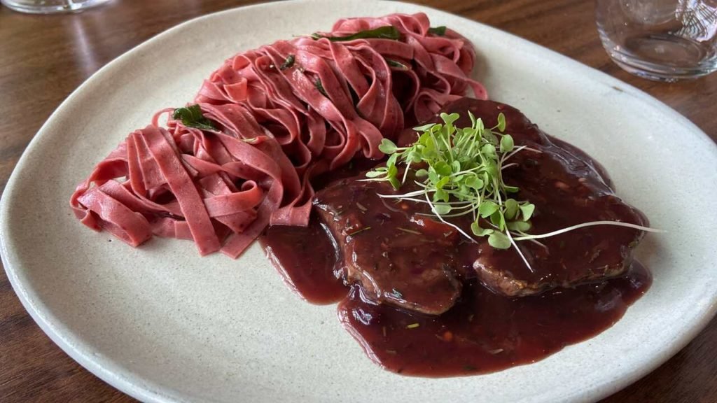 Foto de macarrao com dois pedaços de carne em um prato