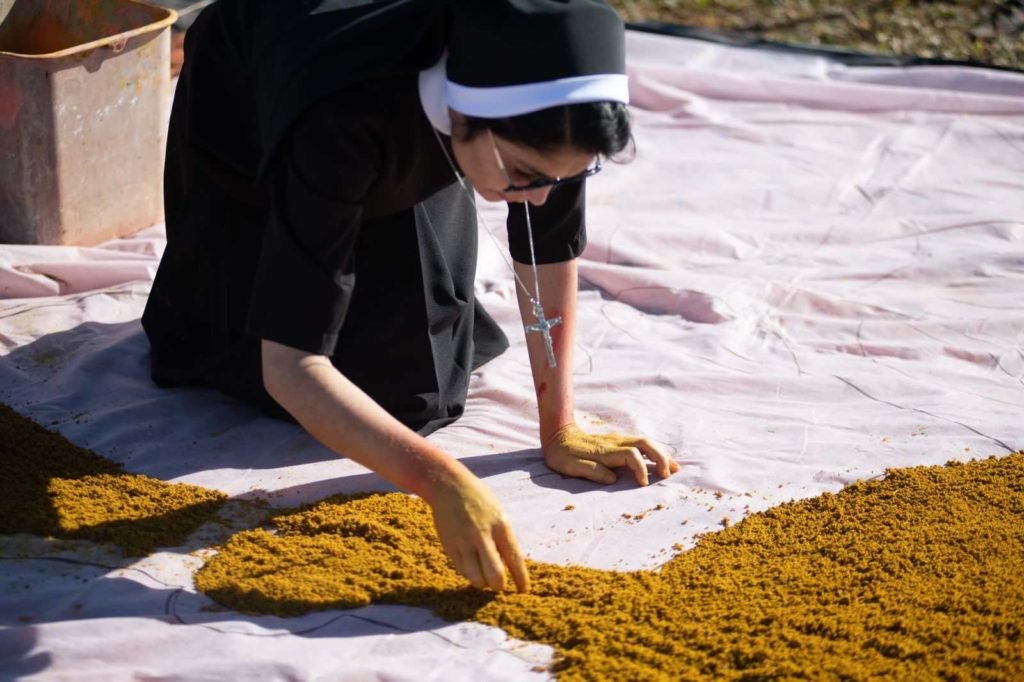 Freira coloca terra em tapete de Corpus Christi