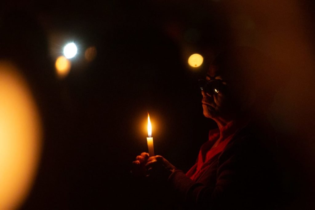 Segurando velas, fiéis participam da procissão com o Santíssimo Sacramento, que percorre o quadrilátero da Esplanada dos Ministérios de frente para a Catedral de Brasília. O Santíssimo Sacramento é transportado no mesmo papamóvel usado na visita do Papa João Paulo II a Brasília.