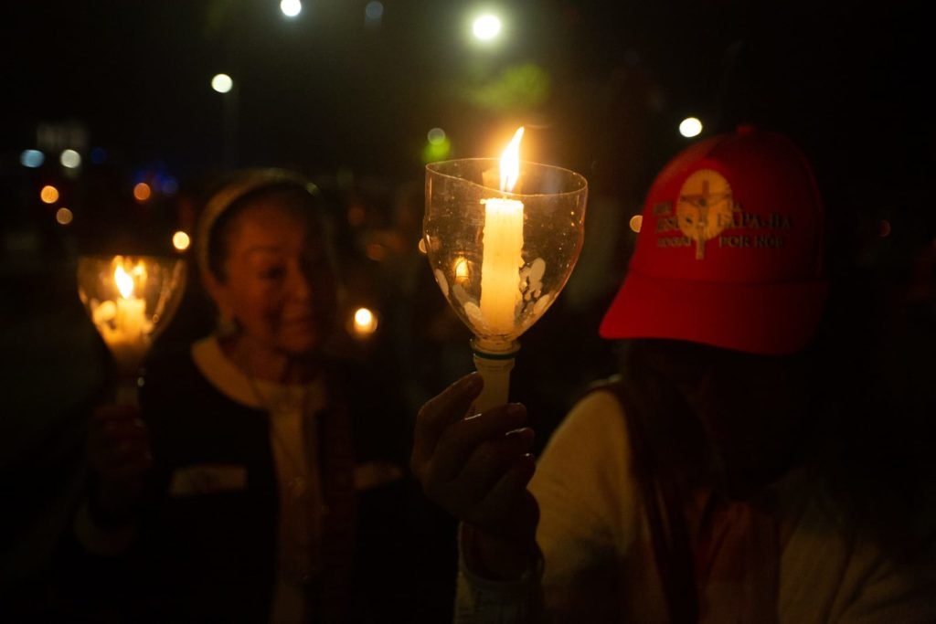 Segurando velas, fiéis participam da procissão com o Santíssimo Sacramento, que percorre o quadrilátero da Esplanada dos Ministérios de frente para a Catedral de Brasília. O Santíssimo Sacramento é transportado no mesmo papamóvel usado na visita do Papa João Paulo II a Brasília.