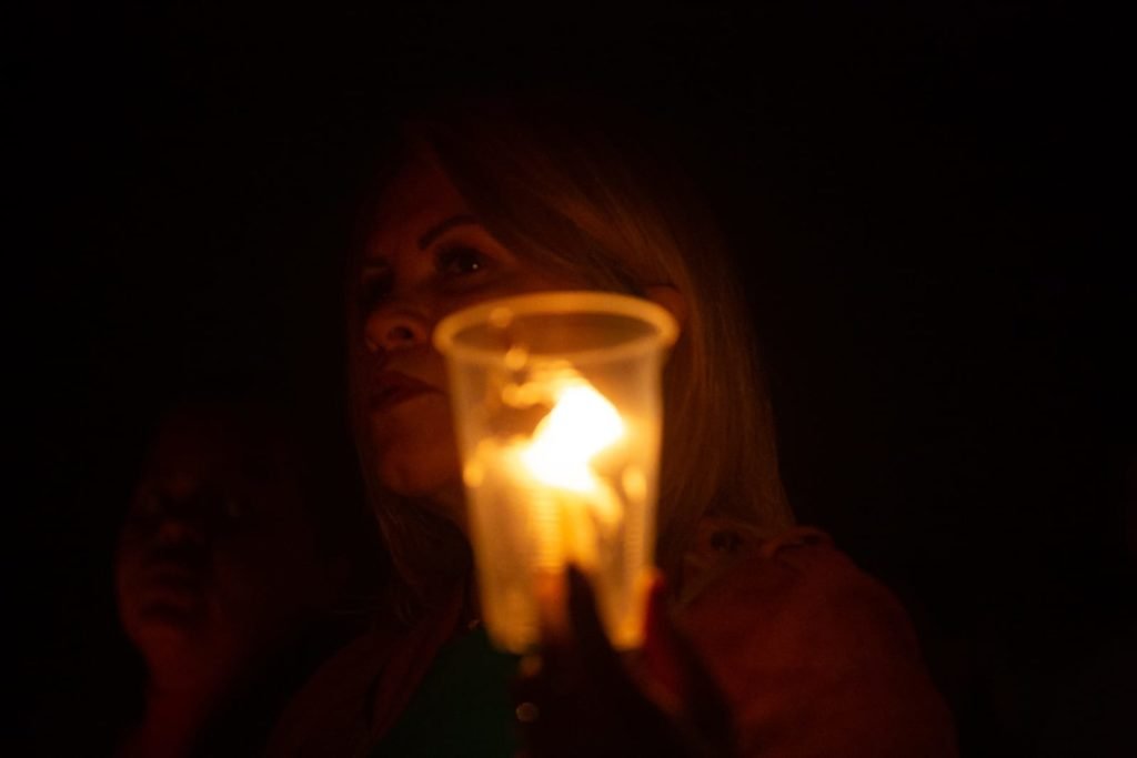 Segurando velas, fiéis participam da procissão com o Santíssimo Sacramento, que percorre o quadrilátero da Esplanada dos Ministérios de frente para a Catedral de Brasília. O Santíssimo Sacramento é transportado no mesmo papamóvel usado na visita do Papa João Paulo II a Brasília.