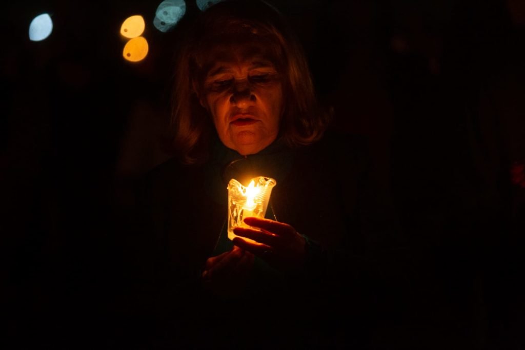 Segurando velas, fiéis participam da procissão com o Santíssimo Sacramento, que percorre o quadrilátero da Esplanada dos Ministérios de frente para a Catedral de Brasília. O Santíssimo Sacramento é transportado no mesmo papamóvel usado na visita do Papa João Paulo II a Brasília.