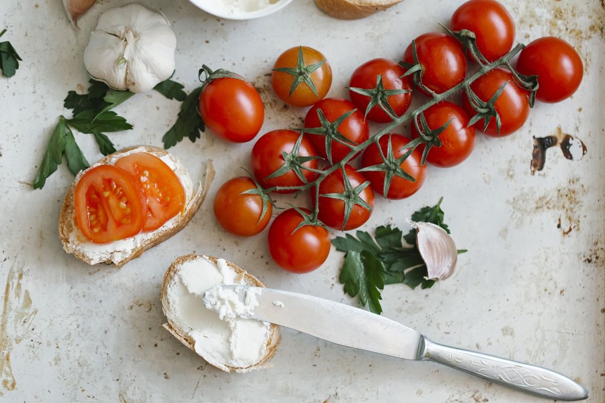 Foto colorida de torrada integral com tomate e cream cheese - Metrpoles