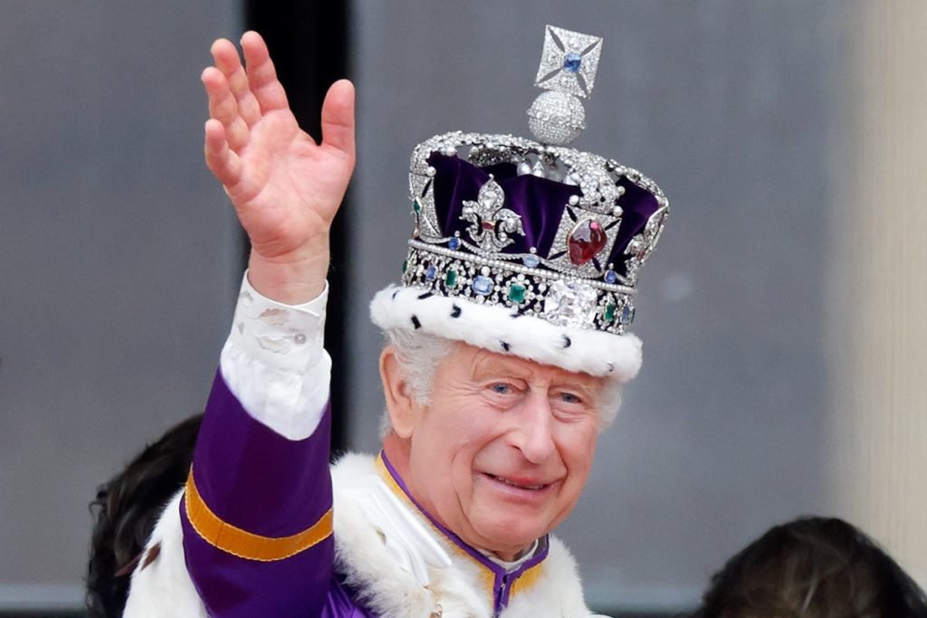 Foto colorida de homem branco, idoso, com uma coroa e acenando - Metrópoles