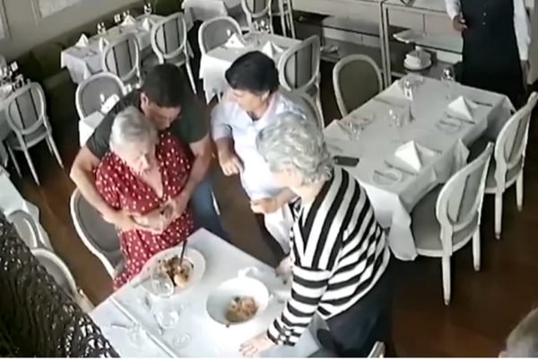 Imagem mostra o momento em que o ex-ministro de Bolsonaro João Roma salva idosa que se engasgava - Metrópoles