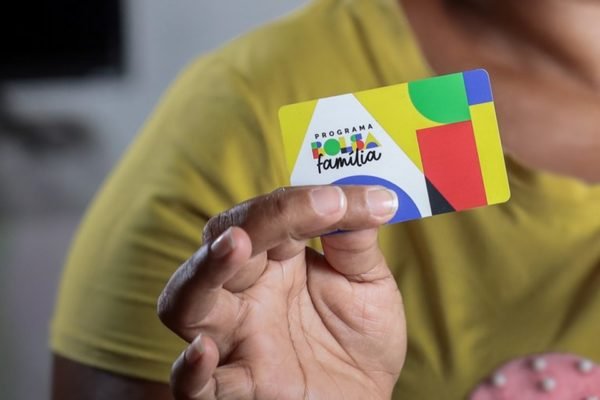 Imagem colorida com Pessoa mostra cartão do Bolsa Família - Metrópoles