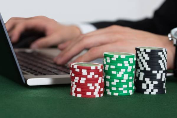 empresário com smartphone jogando poker online e mesa de cassino