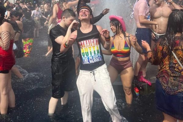 Foto colorida de Noah Schnapp curtindo sua primeira parada gay enquanto usa camisa da comunidade lgbtqiap+ - Metrópoles