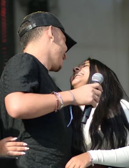 joao gomes de blusa preta e bone preto olha para namorada, mulher de cabelos castanhas que veste blusa branca - metrópoles