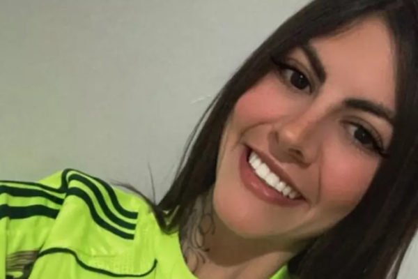 Imagem colorida da torcedora do Palmeiras Gabriela Anelli Marchiano; ela sorri em foto usando a camiseta do time na cor amarelo marca texto- Metrópoles