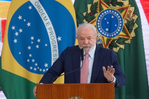 imagem colorida presidente lula sanciona Minha Casa Minha Vida, com bandeira do Brasil e brasão da República ao fundo - Metrópoles