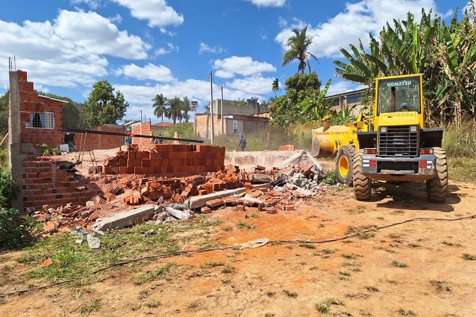 Caminhão amarelo demole casa irregular