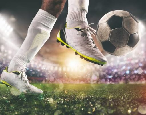 Fotografia colorida mostrando close em pé de jogador de futebol chutando bola-Metrópoles