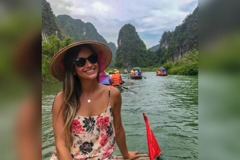 Mulher com chapéu e óculos em um barco no mar - Metrópoles