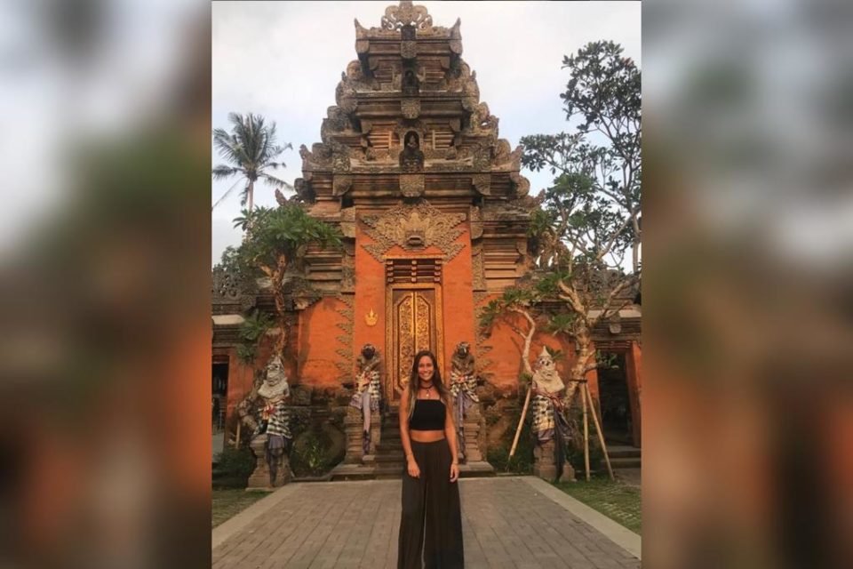 Mulher com roupa preta em frente a uma arquitetura em Bali, na Indonesia- Metrópoles