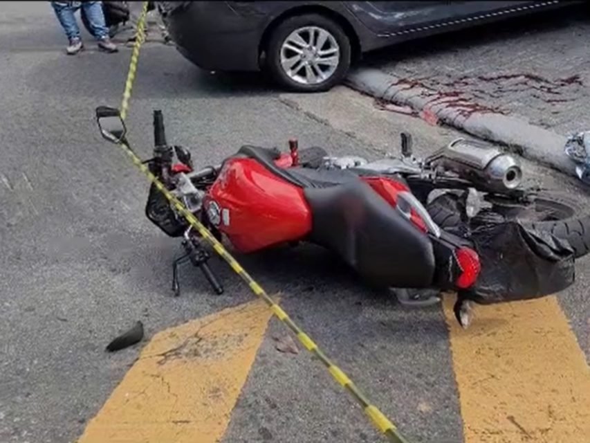 Foto colorida de moto usada por suspeitos de assalto caída no chão