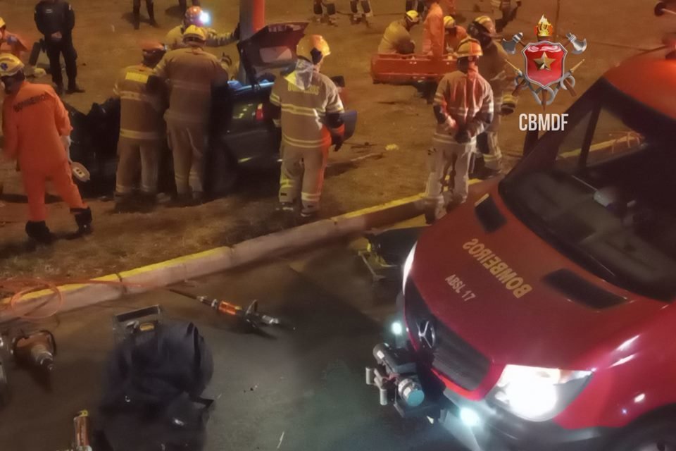 Foto de um carro BMW preto batido em poste
