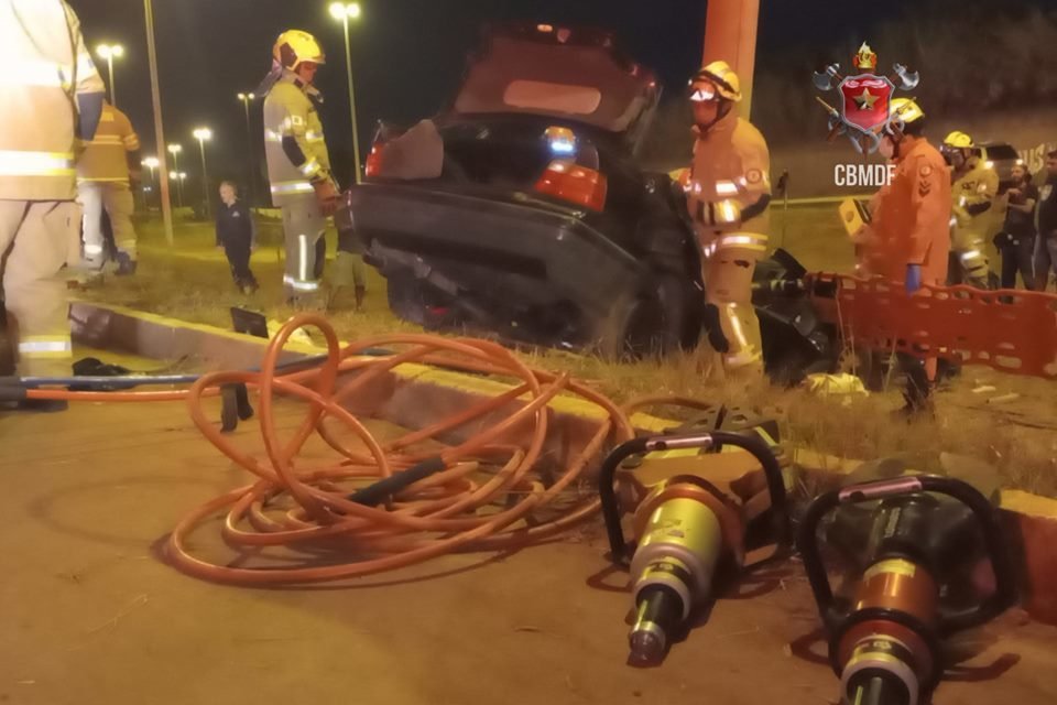 Foto de um carro BMW preto batido em poste