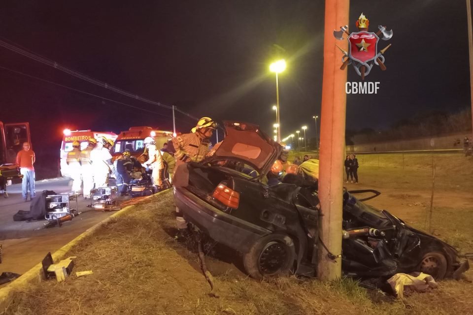 Foto de um carro BMW preto batido em poste