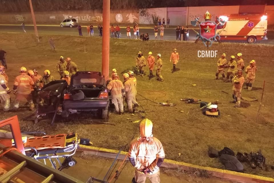 Foto de um carro BMW preto batido em poste