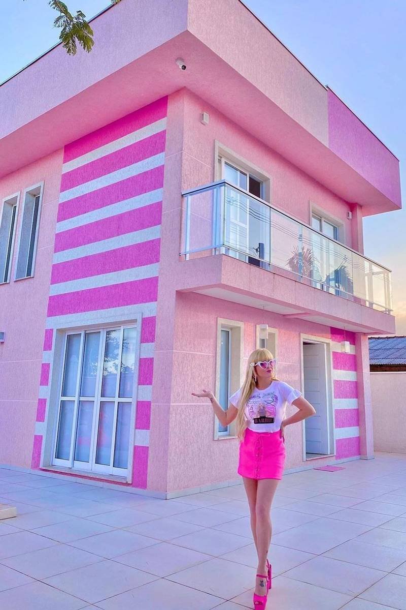 Uma casa rosa com um exterior rosa e uma porta rosa.