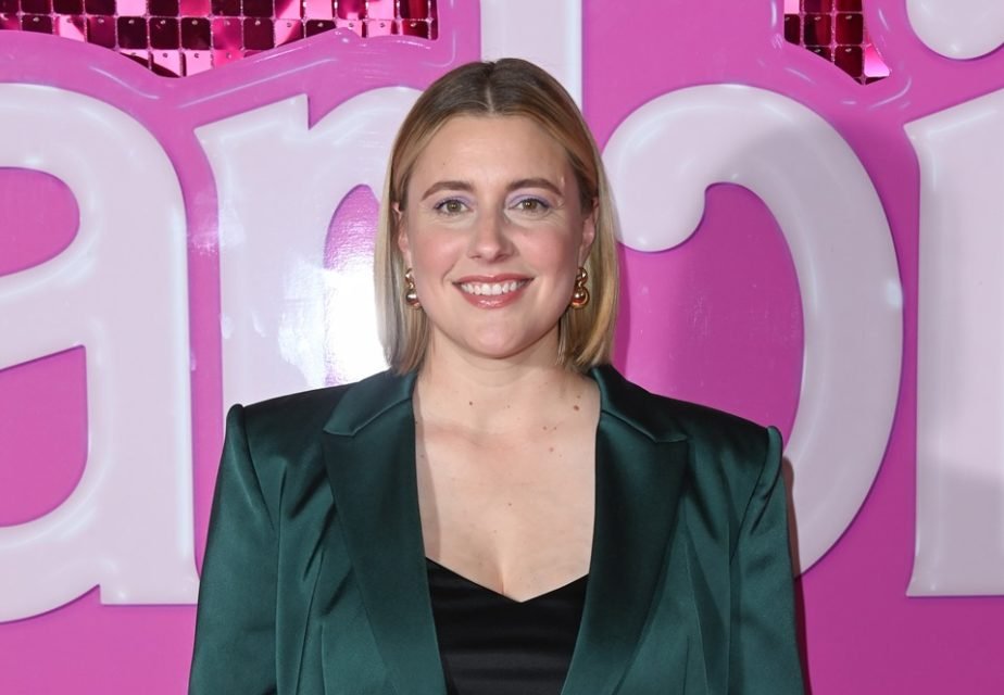 Greta Gerwig em frente a painel da Barbie - Metrópoles