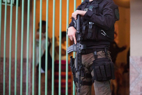 Policial civil do Distrito Federal fardado e segurando arma