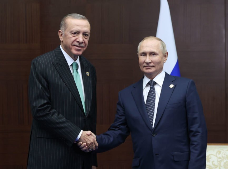 Imagem colorida de Erdogan e Putin apertando as mãos - Metrópoles