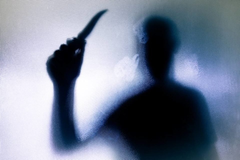 Imagem colorida mostra a sombra de homem com faca na mão - Metrópoles